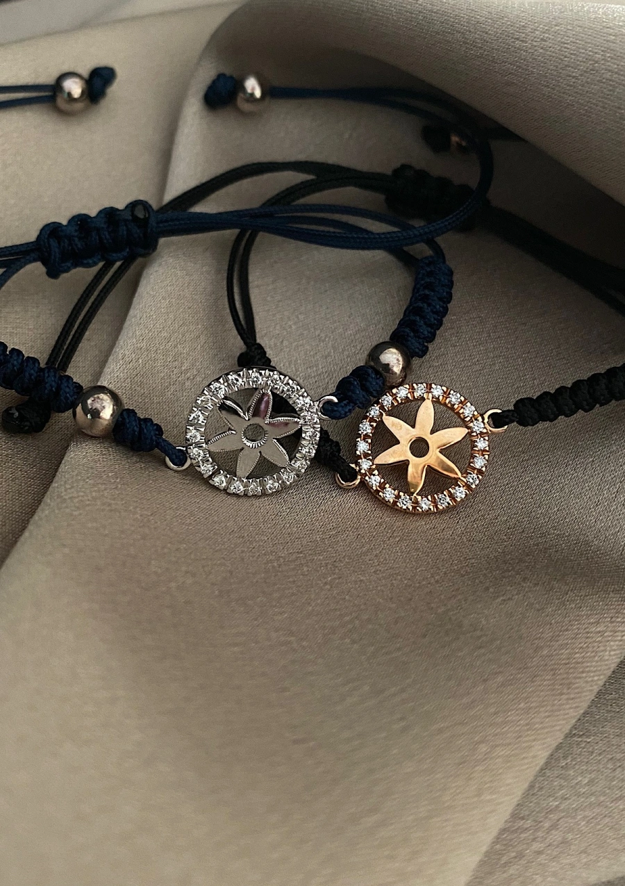 NAUTICA 18K gold diamond and macramé thread charm bracelet.