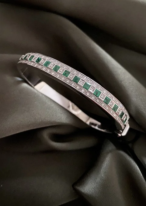 MORRIÑA 18K white gold bangle with diamonds and emeralds.